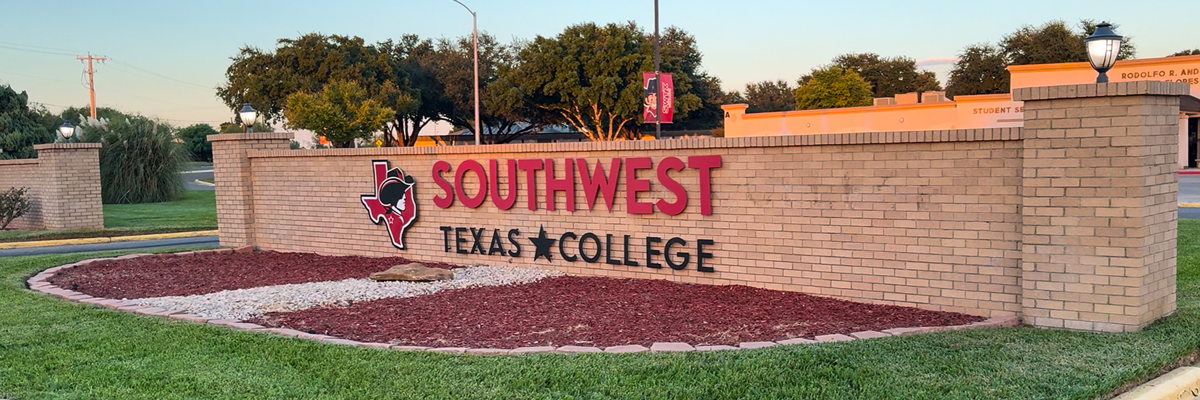 SWTJC Brick Wall Entrance with colorful flowers planted in the foreground